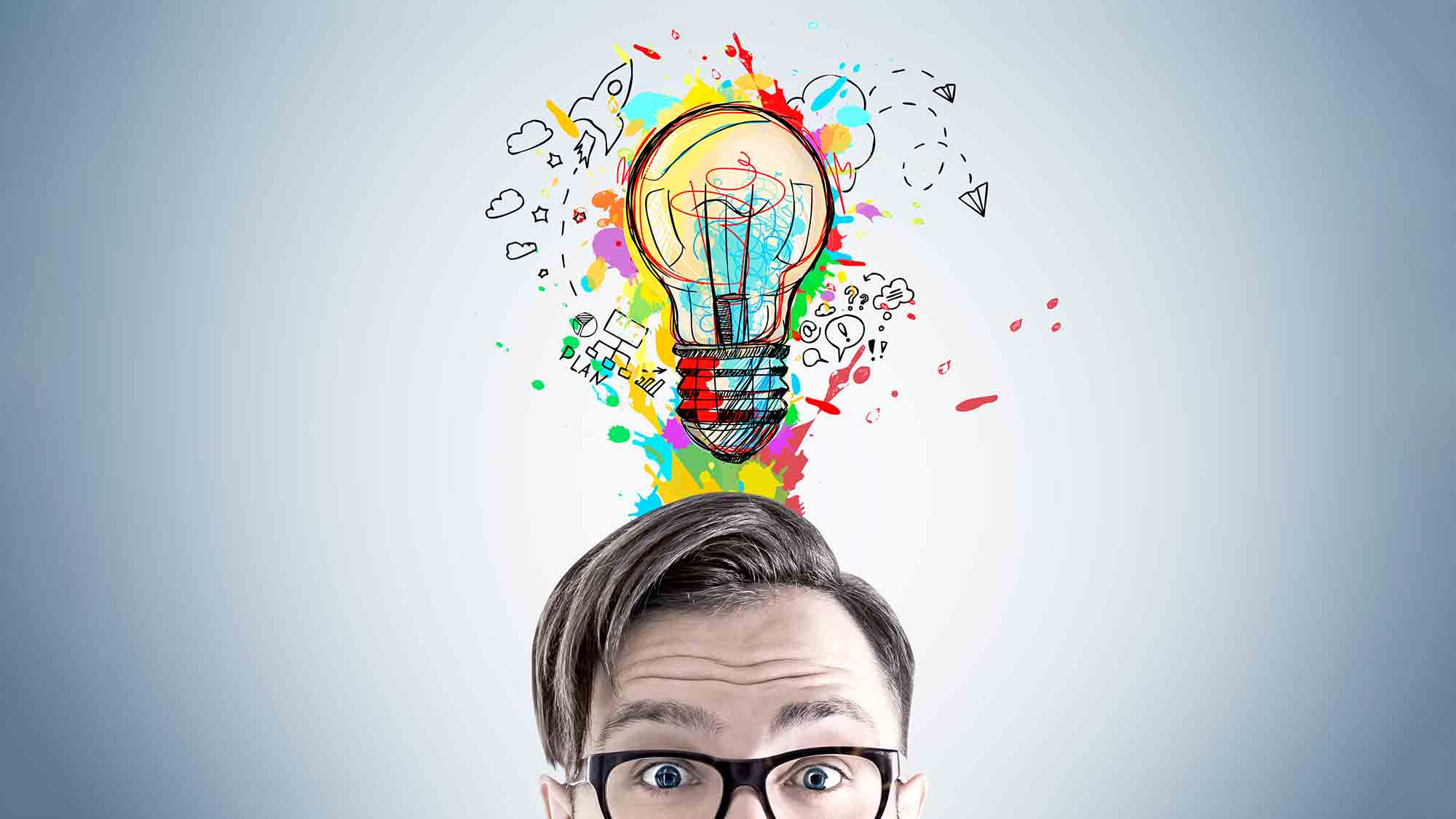 Eine Person mit Brille blickt mit großen Augen nach oben. Über ihrem Kopf befindet sich eine farbenfrohe, abstrakte Illustration einer Glühbirne, umgeben von verschiedenen Symbolen und Kritzeleien, die Kreativität und Ideen darstellen. Der Hintergrund ist in einer schlichten hellen Farbe gehalten.