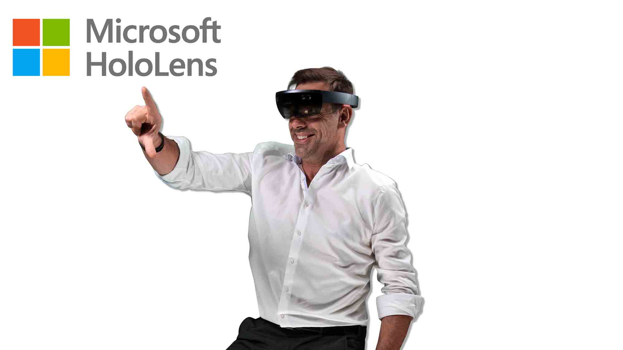 Ein lächelnder Mann in weißem Hemd und schwarzer Hose interagiert mit einem virtuellen Objekt, während er ein Microsoft HoloLens-Headset trägt. Das Microsoft HoloLens-Logo wird in der oberen linken Ecke des Bildes angezeigt.